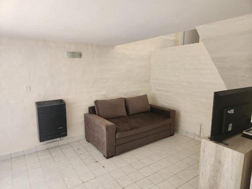 Una sala de estar con un sofá y un televisor. en Beautiful Casa Madrynense, en Puerto Madryn