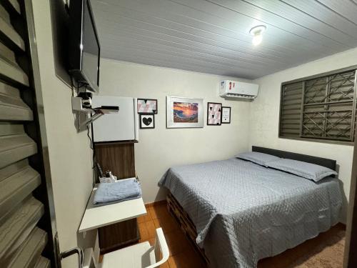 a bedroom with a bed and a flat screen tv at Casa Recanto 2 quartos in Rio Verde