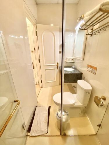 a bathroom with a toilet and a glass shower at Tulip Hotel 3 in Da Lat