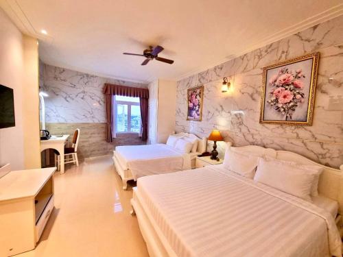 a bedroom with two beds and a stone wall at Tulip Hotel 3 in Da Lat