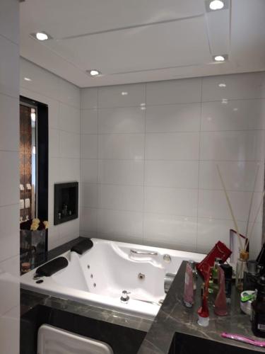 a bathroom with a tub and a large mirror at Apartamento grande in Caxias do Sul