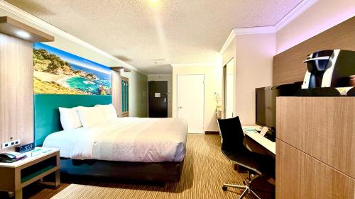 a hotel room with a bed and a desk and a television at Quality Inn & Suites Los Angeles Airport - LAX in Inglewood