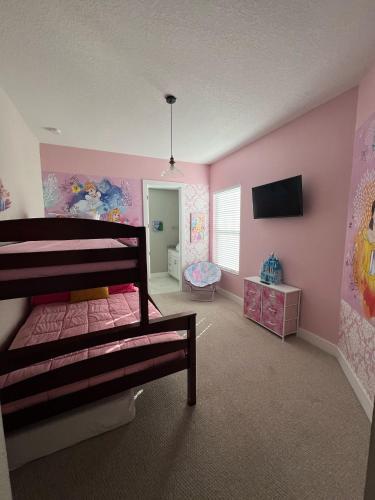 a bedroom with a bunk bed and pink walls at Disney here we go in Orlando