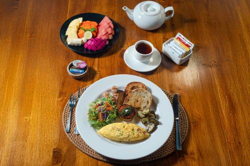 a table with a plate of food and a cup of coffee at Puri Andong Villa in Ubud