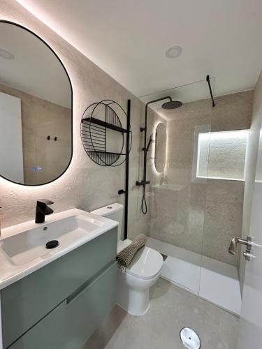 a bathroom with a sink and a toilet and a mirror at AeroSuites202 Alojamiento Madrid in Madrid