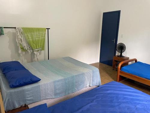 a bedroom with two beds and a lamp on a table at Casa em Camburi, Sertão do Piavu in São Sebastião