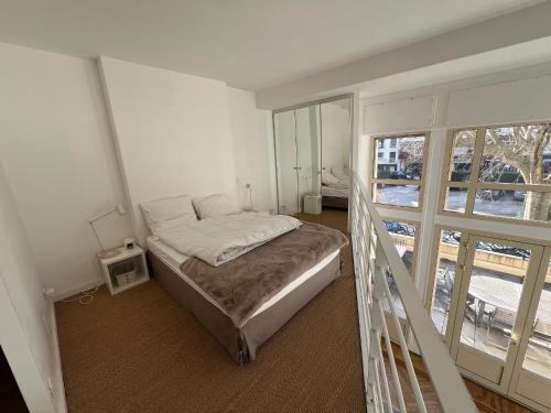 a bedroom with a bed and a large window at Appartement T4 Duplex Centre Arcachon, Terrasse Sud, Proche Plage et Commerces, Parking Inclus - FR-1-474-3 in Arcachon