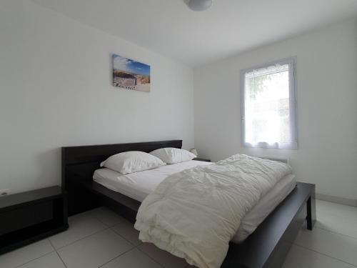 une chambre avec un lit avec des draps blancs et une fenêtre dans l'établissement Villa moderne 6 pers. proche plage, jardin, barbecue - FR-1-476-36, à La Faute-sur-Mer