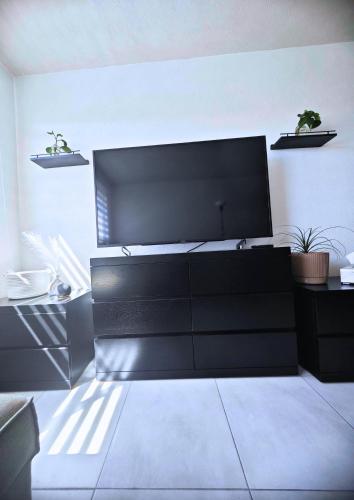 a black dresser with a large screen in a room at Chantli - Departamento Centro Medico IMSS in Guadalajara