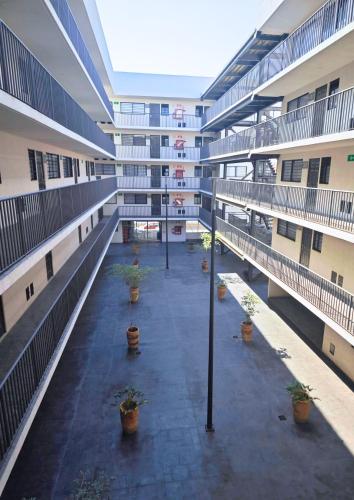 an empty courtyard of an apartment building with potted plants at Chantli - Departamento Centro Medico IMSS in Guadalajara