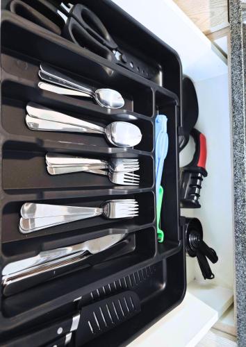 a black drawer filled with utensils in a cabinet at Chantli - Departamento Centro Medico IMSS in Guadalajara