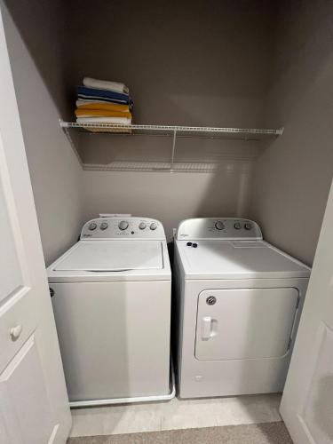 a small laundry room with a washer and dryer at Disney here we go in Orlando