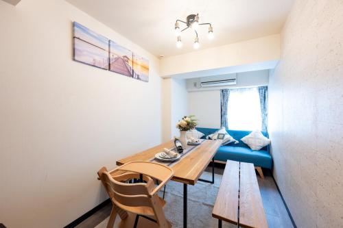 a dining room with a table and a blue couch at 新宿駅まで12分渋谷駅まで22分最大8名様宿泊可能4ベッドルーム in Ogikubo