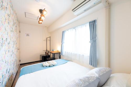 a bedroom with a bed and a window at 新宿駅まで12分渋谷駅まで22分最大8名様宿泊可能4ベッドルーム in Ogikubo