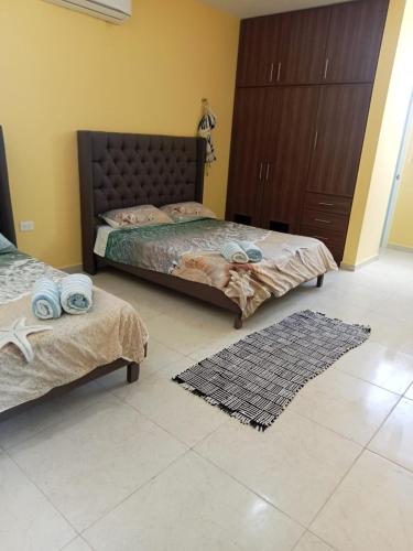 a bedroom with two beds and a tiled floor at Chicxulub Puerto Beach Penthouse in Chicxulub