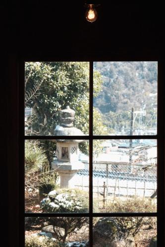 a window view of a fountain through a window at Guesthouse SHIGI in Nakatsugawa