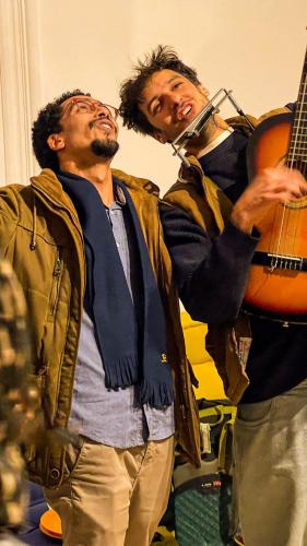 two men standing next to each other with a guitar at Ithaka Raml Hostel in Alexandria