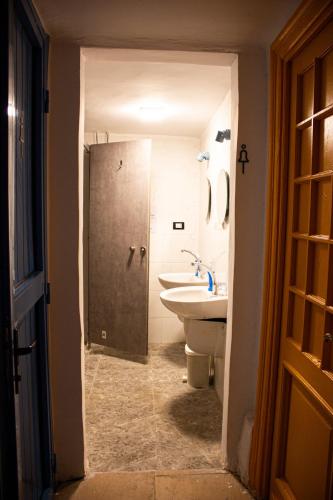 a bathroom with a sink and a toilet and a shower at Ithaka Raml Hostel in Alexandria