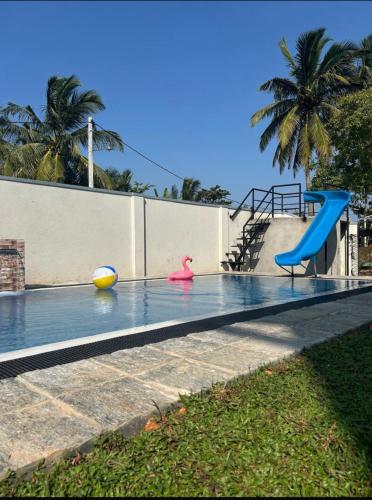 a swimming pool with a slide and a playground at Bolgoda Lake Villa in Moratuwa