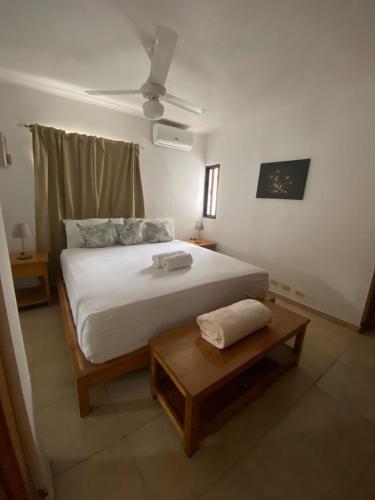 a bedroom with a large bed and a table at Mila's House in La Romana