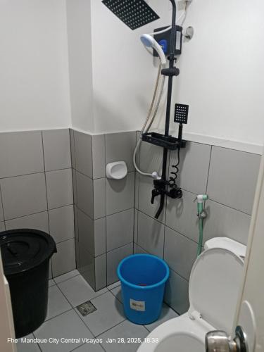 a bathroom with a shower with a toilet and a bucket at Lloyds Barato 2BR Condo Unit 6paxMax in Mandaue City