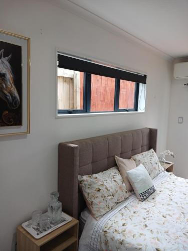 a bedroom with a bed with a horse picture on the wall at Luxury and Nature View Stay in Helensville