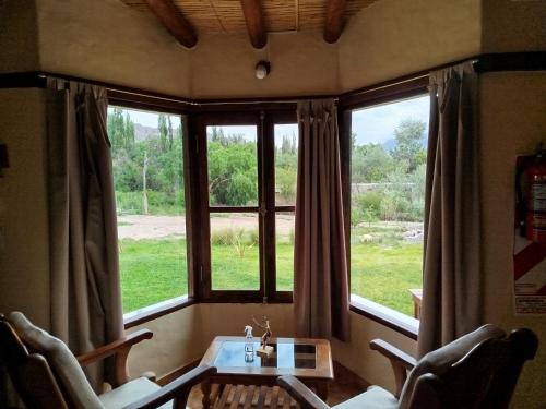 a room with a table and chairs and a window at La Herencia Tilcara in Tilcara
