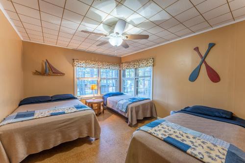 une chambre avec deux lits et un ventilateur de plafond dans l'établissement Cabin O' Pines - A Family Friendly Resort, à Orr