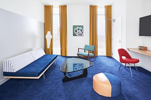 a living room with a couch and a table and a tv at The Durham Hotel in Durham