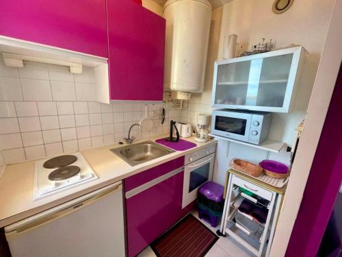 Elle comprend une petite cuisine avec des placards violets et un évier. dans l'établissement Appartement T2 Confortable, 4/5 Pers, Plage Grazel, Parking Privé - FR-1-796-86, à Gruissan