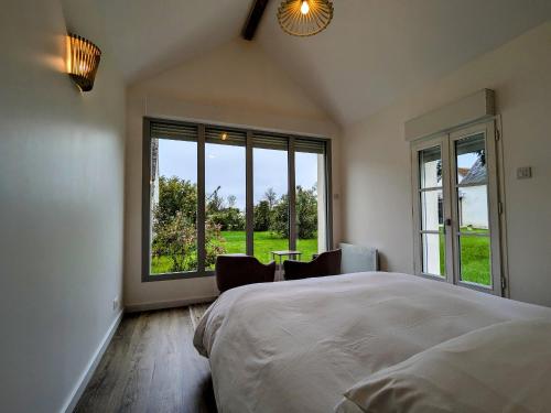 une chambre avec un grand lit et une grande fenêtre dans l'établissement Maison moderne avec piscine sécurisée à La Vernelle - FR-1-591-721, à La Vernelle