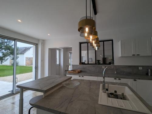 - une cuisine avec un comptoir et un évier dans l'établissement Maison moderne avec piscine sécurisée à La Vernelle - FR-1-591-721, à La Vernelle