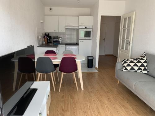 une cuisine et un salon avec une table et des chaises dans l'établissement Appartement moderne proche plage pour 4 personnes - FR-1-482-152, à Fort-Mahon-Plage