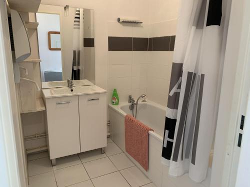 une salle de bain avec un lavabo et une baignoire dans l'établissement Appartement moderne proche plage pour 4 personnes - FR-1-482-152, à Fort-Mahon-Plage