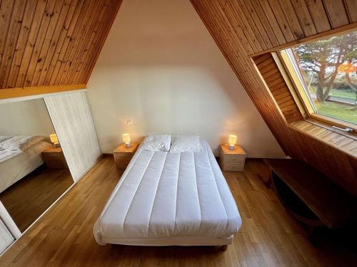 - une chambre mansardée avec un lit et 2 fenêtres dans l'établissement Erdeven - Villa 4 pièces - 114 m² - 8 pers - À 500 m de la plage - FR-1-479-215, à Erdeven