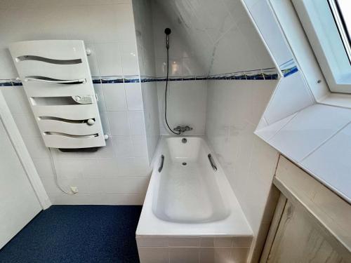d'une petite salle de bains d'angle avec une baignoire. dans l'établissement Erdeven - Villa 4 pièces - 114 m² - 8 pers - À 500 m de la plage - FR-1-479-215, à Erdeven