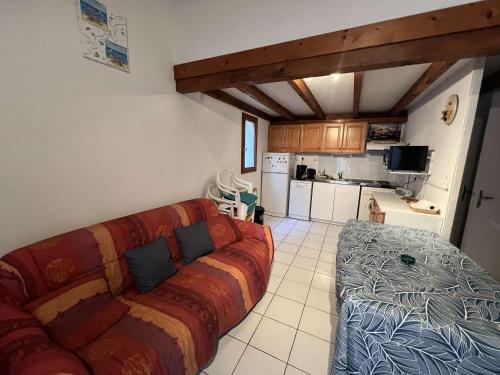 un salon avec un canapé et une cuisine dans l'établissement Pavillon cosy avec terrasse et parking pour 4 personnes - FR-1-701-87, à Valras-Plage