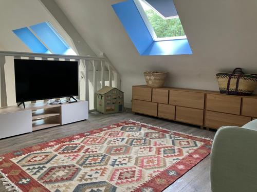 - un salon avec une télévision à écran plat et un tapis dans l'établissement Charmante maison avec cheminée et grande terrasse - FR-1-712-91, à Villers-sur-Mer