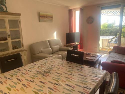 un salon avec une table et un canapé dans l'établissement Appartement rénové 2 pièces proche plage, 4 pers, parking privé - FR-1-782-74, au Barcarès