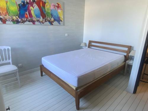 une chambre avec un lit et un tableau au mur dans l'établissement Appartement rénové 2 pièces proche plage, 4 pers, parking privé - FR-1-782-74, au Barcarès