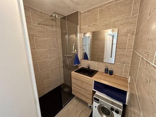 une salle de bain avec douche et lavabo et une machine à laver dans l'établissement T2 Cabine Climatisé à Argelès avec Parking - FR-1-388-228, à Argelès-sur-Mer