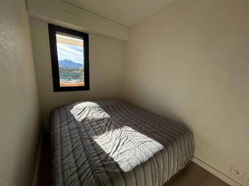 une petite chambre avec un lit et une fenêtre dans l'établissement T2 Cabine Climatisé à Argelès avec Parking - FR-1-388-228, à Argelès-sur-Mer