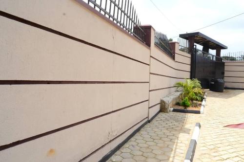 a side of a building with a fence and plants at Relax, Unwind, 2 Bed Haven near Kavumba Rec Center in Wakiso