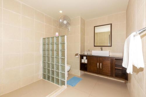 Un baño con lavabo, inodoro y espejo. en Naiharn beach sands Apartment, en Nai Harn Beach