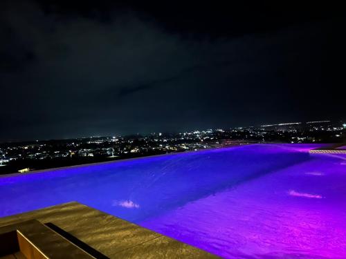 a view of a city at night with purple lights at 1106 LaGrande2 11floor rooftop swiming angeles Walking street in Angeles
