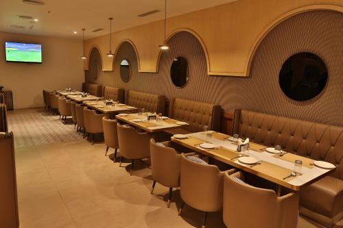 a row of tables and chairs in a restaurant at Royal Ritis in Belgaum