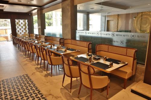 a row of tables and chairs in a restaurant at Royal Ritis in Belgaum