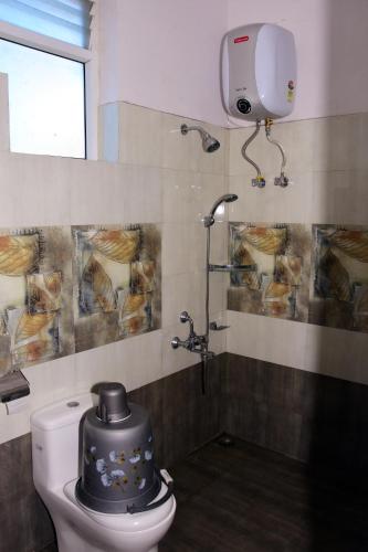 a bathroom with a toilet with a hat on it at Vanam Holidays in Ooty