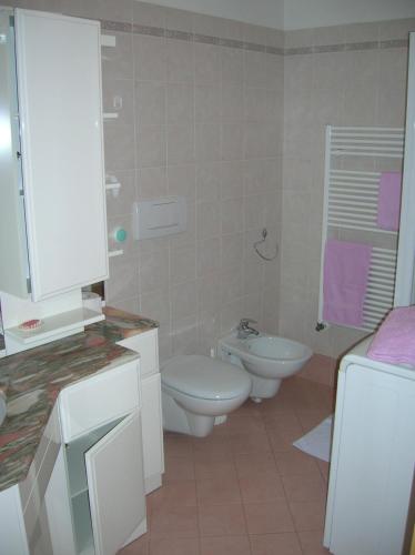 a white bathroom with a toilet and a sink at Appartamento Zorzi in Ziano di Fiemme