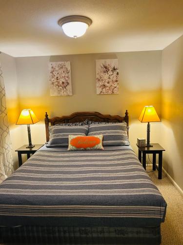 a bedroom with a large bed with two lamps at Emerald City Studio Suite in Eugene